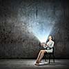 Image of businesswoman sitting on chair with tablet pc in hands