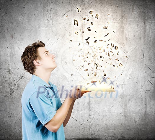 Young man with opened book and characters flying out Young man with opened book and characters flying out