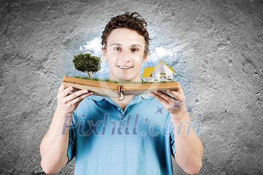 Young man in casual holding opened book with green tree Young man in casual holding opened book with green tree