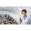 Cute school boy examining objects with magnifying glass