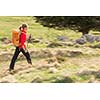 Pretty, young woman hiking in mountains (motion blurred image)