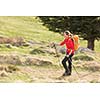 Pretty, young woman hiking in mountains (motion blurred image)