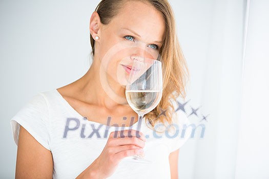 Gorgeous young woman with a glass of wine, smelling the lovely drink, savouring   every sip (shallow DOF; color toned image)