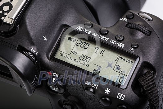 Professional modern DSLR camera - detail of the top LCD with settings - shutter speer, aperture, ISO, AF mode, battery info, RAW format indication,...