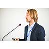 Handsome young man giving a speech at a conference