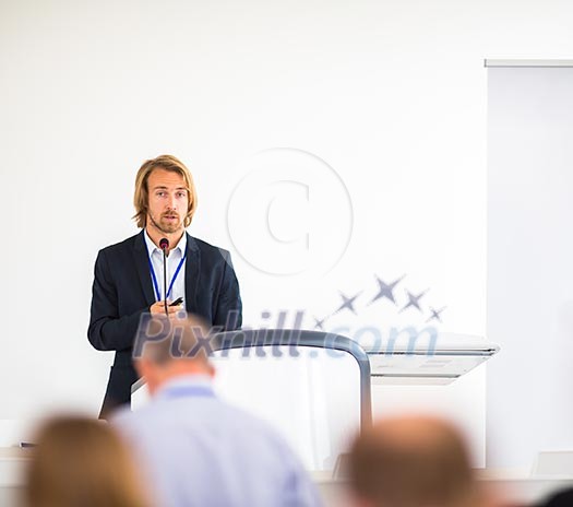 Handsome young man giving a speech at a conference Handsome young man giving a speech at a conference