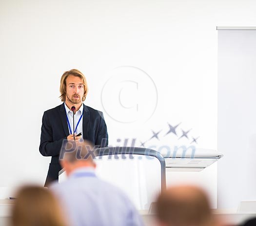 Handsome young man giving a speech at a conference