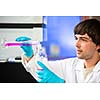 Young male researcher carrying out scientific research in a lab (shallow DOF; color toned image)