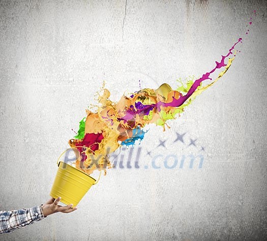 Close up of hand splashing colorful paint from colorful bucket Close up of hand splashing colorful paint from colorful bucket