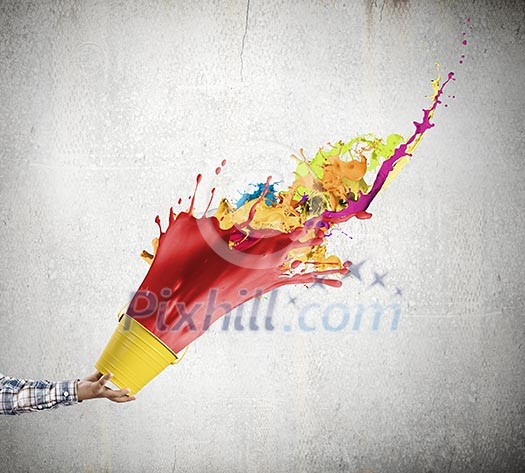 Close up of hand splashing colorful paint from colorful bucket Close up of hand splashing colorful paint from colorful bucket
