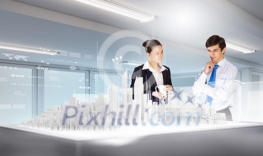 Two young businesspeople looking at construction project Two young businesspeople looking at construction project