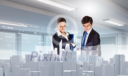 Two young businesspeople looking at construction project Two young businesspeople looking at construction project