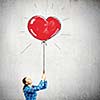 Young woman in casual holding heart shaped balloon