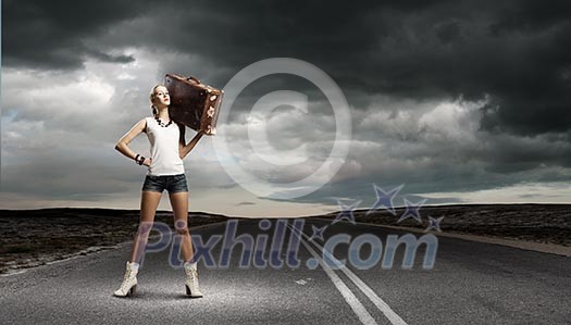 Young woman hiker walking with suitcase on shoulder