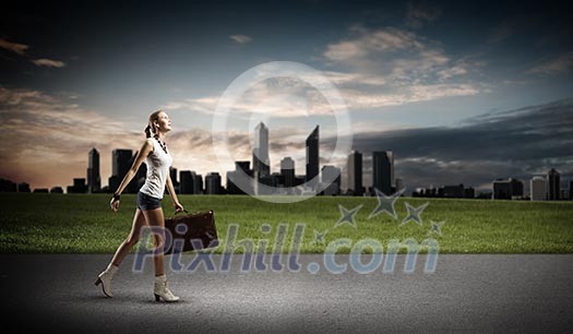 Young woman hiker walking with suitcase in hand Young woman hiker walking with suitcase in hand