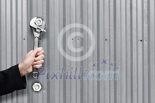 Close up of businessman hand fixing mechanism with spanner Close up of businessman hand fixing mechanism with spanner