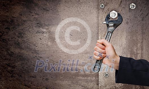 Close up of businessman hand fixing mechanism with spanner Close up of businessman hand fixing mechanism with spanner