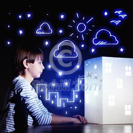 Cute little boy looking at model of house