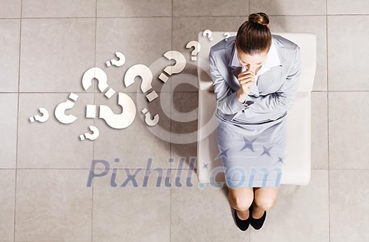 Top view of thoughtful businesswoman sitting on chair Top view of thoughtful businesswoman sitting on chair