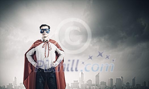 Young confident superman in mask and cape Young confident superman in mask and cape