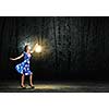 Young woman in blue dress walking in night wood