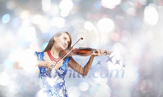 Young attractive woman in blue dress playing violin
