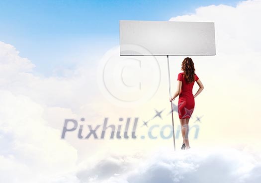 Rear view of woman in red dress with blank banner