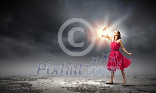 Young woman in red dress with lantern