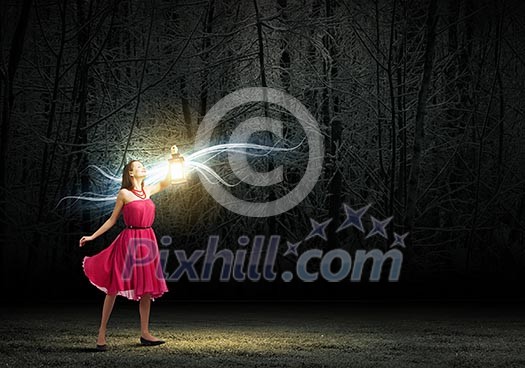 Young woman in red dress walking in night wood Young woman in red dress walking in night wood