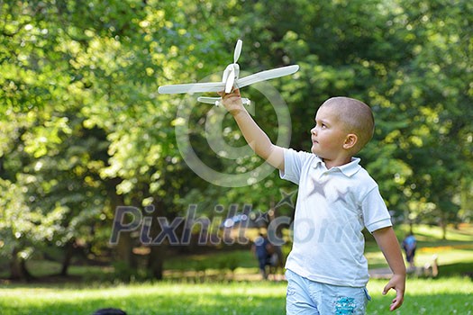happy boy play and  throw airplane in park