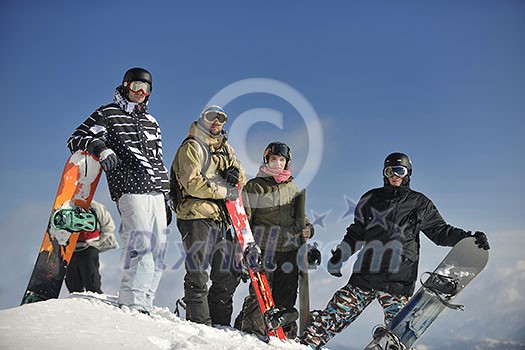 young snowboarders group have fun and relax at sunny winter day on winter season