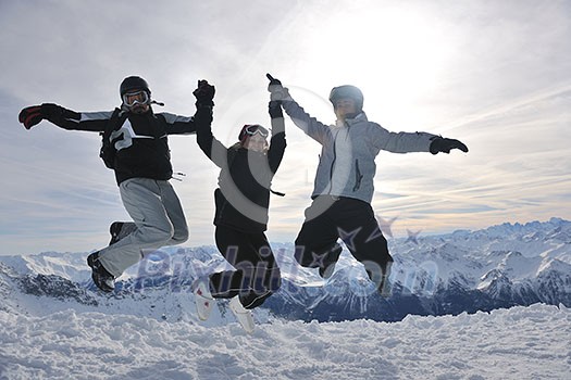 happy people group have fun on snow at winter season on mountain with blue sky and fresh air