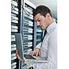 young engeneer business man with thin modern aluminium laptop in network server room