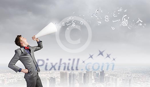 Young excited businessman screaming in paper trumpet Young excited businessman screaming in paper trumpet