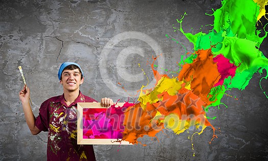 Young handsome man painter with brush in hand Young handsome man painter with brush in hand