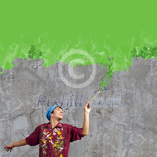 Young handsome man painter with brush in hand Young handsome man painter with brush in hand