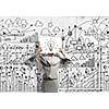 Businesswoman hiding her face with sheet of paper with sketches at background