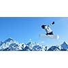 Snowboarder making jump high in clear sky