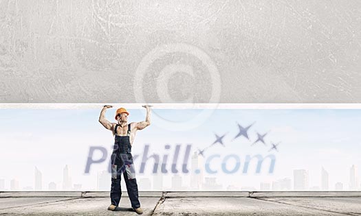 Strong man in uniform lifting wall above head