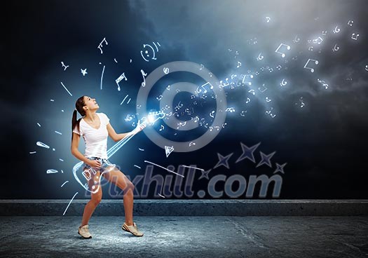 Young girl in shorts playing on imaginary guitar