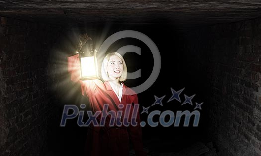 Young blond woman in red cloak with lantern