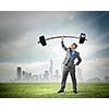 Image of strong businessman lifting barbell above head with one hand