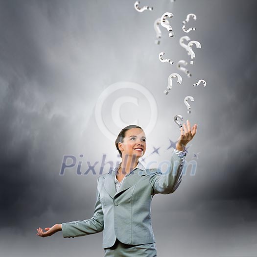 Image of young attractive businesswoman holding question marks in hand