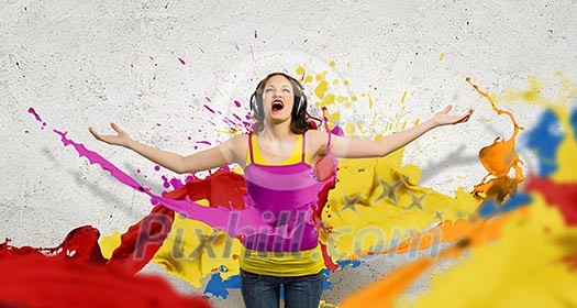 Image of young woman wearing headphones and singing