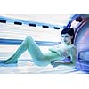 Pretty, young woman tanning her skin in a modern solarium/sunbed