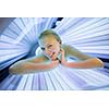 Pretty, young woman tanning her skin in a modern solarium/sunbed