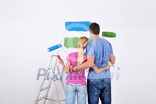 happy young couple paint in green and blue color white wall of their new home happy young couple paint in green and blue color white wall of their new home