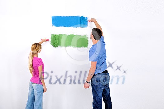 happy young couple paint in green and blue color white wall of their new home happy young couple paint in green and blue color white wall of their new home