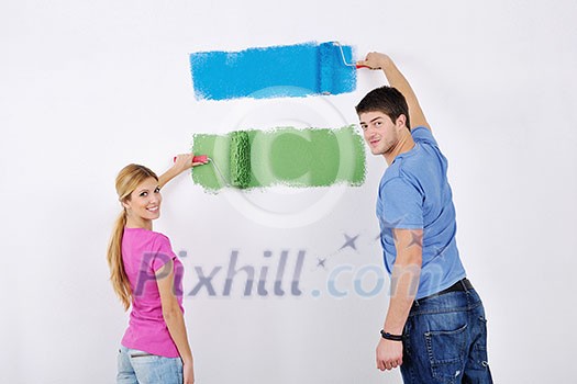 happy young couple paint in green and blue color white wall of their new home happy young couple paint in green and blue color white wall of their new home