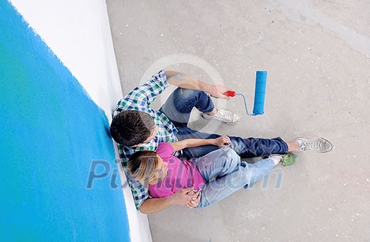 happy young couple relax after painting white wall in green and blue color in their new home happy young couple relax after painting white wall in green and blue color in their new home
